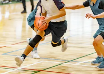Jugador o jugadora de bàsquet amb la pilota a la mà, corrent