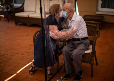 Agustina Canamero, 81 anys, i Pascual Pérez, de 84, s'abracen i es besen a través d'una pantalla de film de plàstic per evitar contagiar-se del coronavirus en una residència. (Foto cedida per Emilio Morenatti/AP)