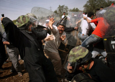 Agents de la policia antidisturbis israelians dispersen manifestants palestins durant enfrontaments en una manifestació contra la construcció de la barrera de separació d'Israel al poble de Beit Sira, a Cisjordània, prop de Ramal·lah, divendres 24 de març de 2006.(Foto cedida per Emilio Morenatti/AP)