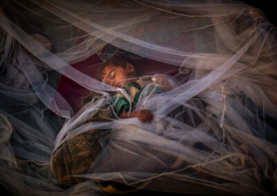 Un nen pakistanès desplaçat de la vall de Swat dorm sota una mosquitera fora de la seva tenda al camp de refugiats de Jalozai, prop de Peshawar, Pakistan, dimarts 26 de maig de 2009. (Foto cedida per Emilio Morenatti/AP)