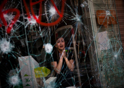 Mirian Burrueco, de 30 anys, reacciona darrere dels vidres trencats de la seva botiga assaltada per manifestants durant els enfrontaments a la vaga general de Barcelona, dijous 29 de març de 2012. Els treballadors espanyols, indignats per les reformes laborals que consideren flagrantment proempresarials, van organitzar dijous una vaga nacional i van intentar aturar el país bloquejant el trànsit, tancant fàbriques i enfrontant-se amb la policia en manifestacions sorolloses. (Foto cedida per Emilio Morenatti/AP)